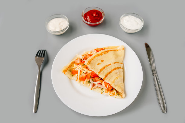 吃有馅料的可丽饼的人。美味的早餐。图片下载