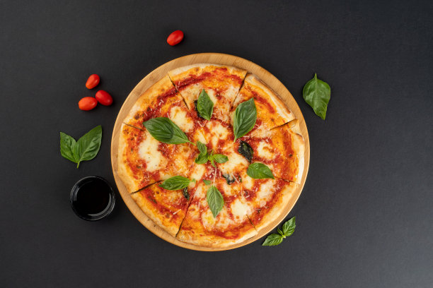 意大利美食：美味的自制马苏里拉奶酪和樱桃番茄披萨，深灰色背景俯视拍摄图片下载