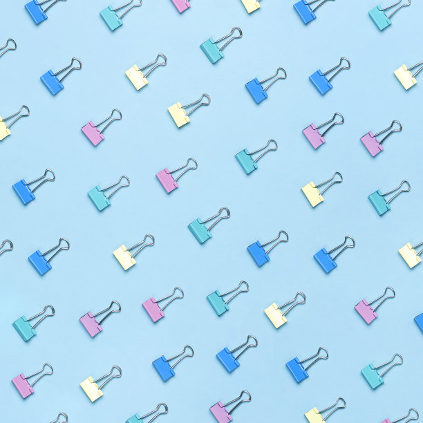 彩色回形针的图案在粉彩蓝色背景顶视图平面铺设复制空间。简约的办公背景，教育背景，创意对象。回到学校概念。广场的格式图片下载