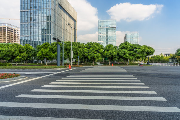 现代城市里空荡荡的马路上有斑马线和摩天大楼图片下载