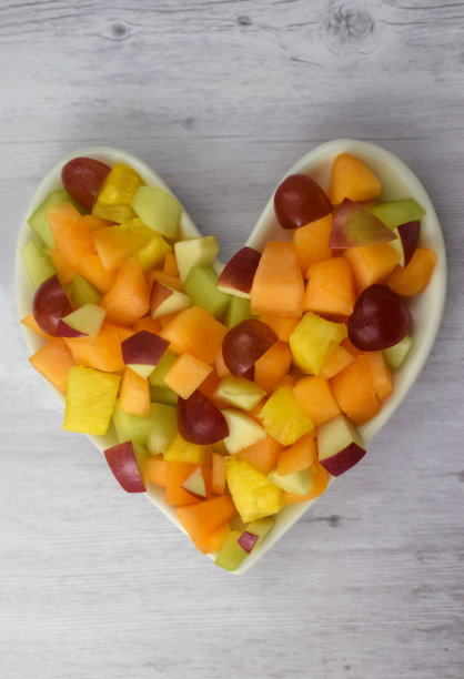木材背景的心脏健康水果沙拉概念图片下载