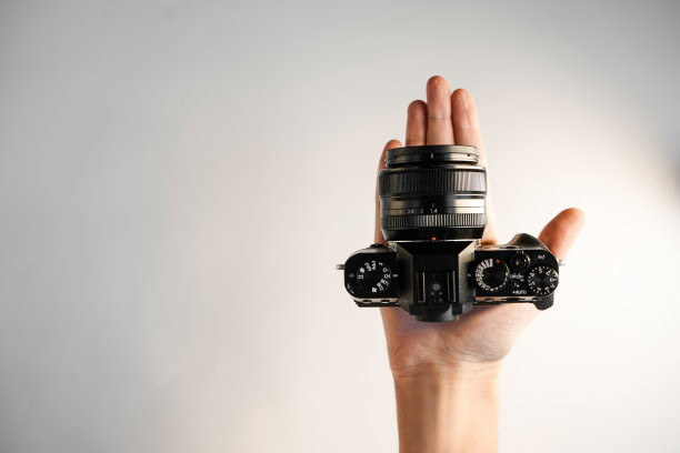 一个男人手里拿着一台小巧的专业单反相机图片下载
