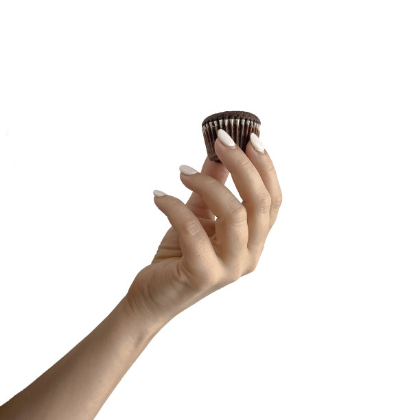 照片中的女性手持纸杯蛋糕在美妙的白色背景图片下载