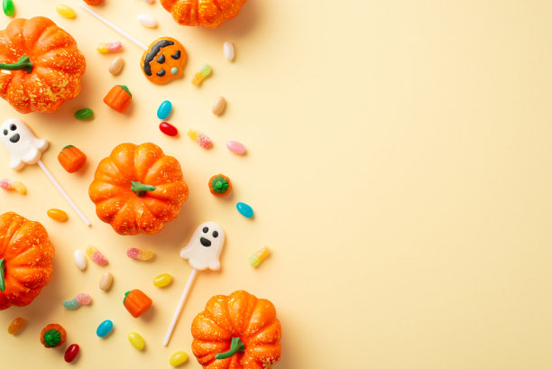 万圣节派对的概念。顶视图照片的南瓜糖果玉米鬼形状的棒棒糖上孤立的米色背景与copyspace图片下载