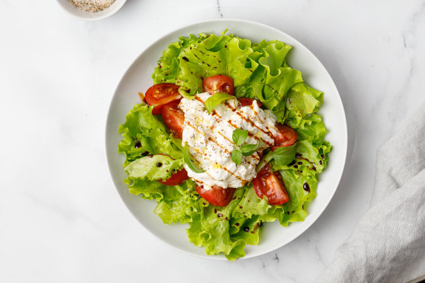 美味的沙拉配上芝士饼，生菜叶，西红柿和酱汁。健康和排毒的食物概念。蔬菜沙拉碗。前视图。图片下载