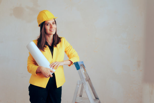 建筑师戴着安全帽，在装修后的房间里拿着蓝图图片下载