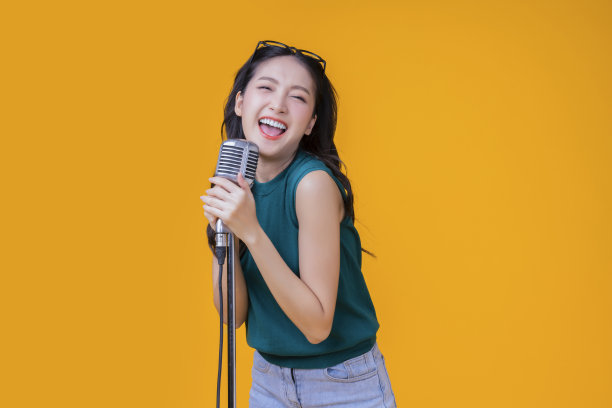 准备派对开朗的亚洲女性签约快乐乐趣露齿微笑大笑穿着休闲的衣服新鲜的动作姿势假装表演在音乐工作室拍摄的黄色背景图片下载