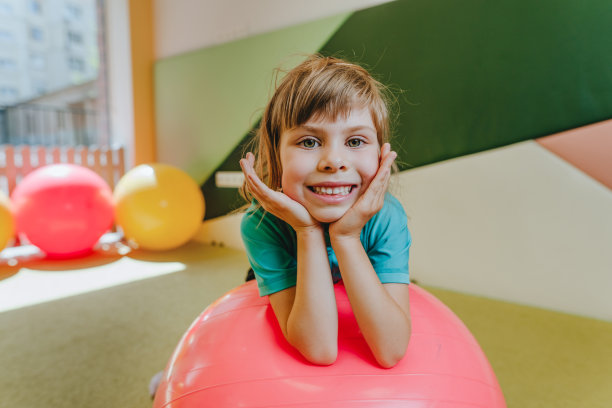 小女孩坐在健身球旁看着镜头图片下载