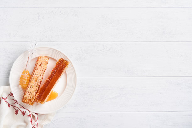 犹太新年。蜂蜜罐，蜂巢，苹果和石榴在白色木制旧质朴的背景表。犹太新年节日贺卡。犹太新年的节日属性。空间的文本图片下载