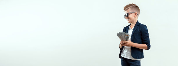 一个富家子弟坐在灯光下，手里拿着一捆美元。金融教育，年轻的百万富翁，投资，贷款，赢钱，分红。传单空白，网站页眉，复制空间。图片下载