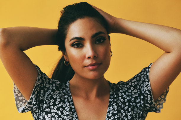 黄色背景下美丽的拉丁美洲女子。图片下载