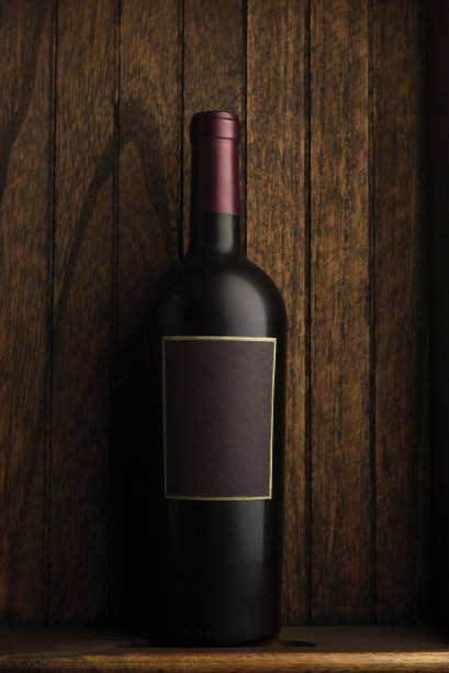 酒瓶静物:一个孤零零的酒瓶放在一个质朴的木盒子里。带有拷贝空间的垂直格式。图片下载