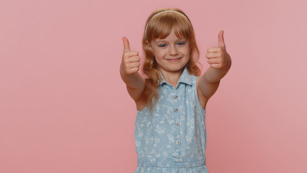 快乐的青春期前的小女孩，赞许地看着镜头竖起大拇指，像是积极的信号图片下载