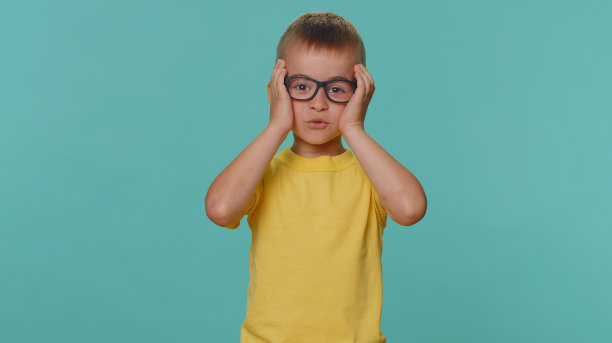 小男孩小男孩看起来很惊讶游戏中奖，彩票目标实现，胜利的好消息图片下载