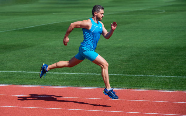 运动健硕的男人穿着运动服在体育场跑道上跑步，耐力图片下载