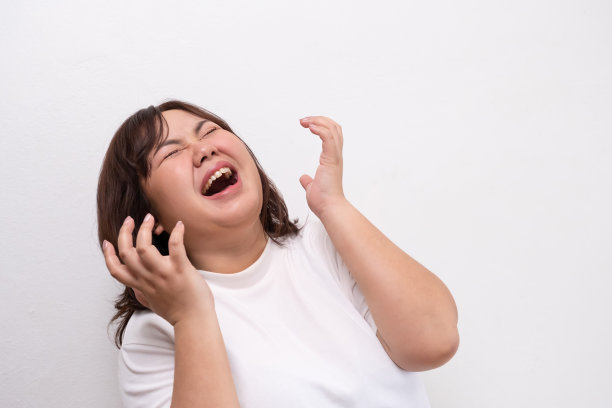 年轻的胖乎乎的亚洲女性在生气或生气时，会带着生气的面部表情尖叫或大声喊叫。人的情感表达。人像拍摄的白色背景与复制空间。图片下载