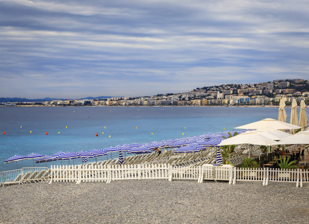 法国尼斯地中海上的圆石滩，带着沙滩伞和椅子图片下载