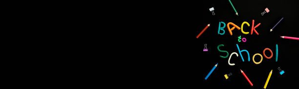 横幅字的多色橡皮泥回到学校和笔，回形针，在黑色背景上俯视素材图片