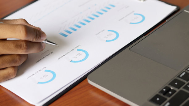 财务图表在办公桌与笔记本电脑，家庭办公室或工作空间。财务会计战略分析概念图片下载