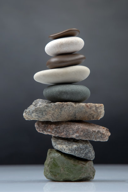 黑色的背景上堆着金字塔般的石头。生活中的稳定与平衡图片下载