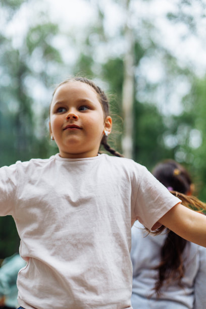 可爱的小女孩和其他小朋友在绿色公园的操场上玩耍。夏令营，旅游中心。户外散步和玩耍，体育活动和健康的生活方式，娱乐图片下载