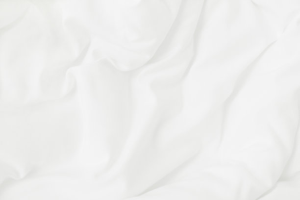 白色的毛毯和被单在睡醒后的卧室里有褶皱或凌乱的纹理。图片下载