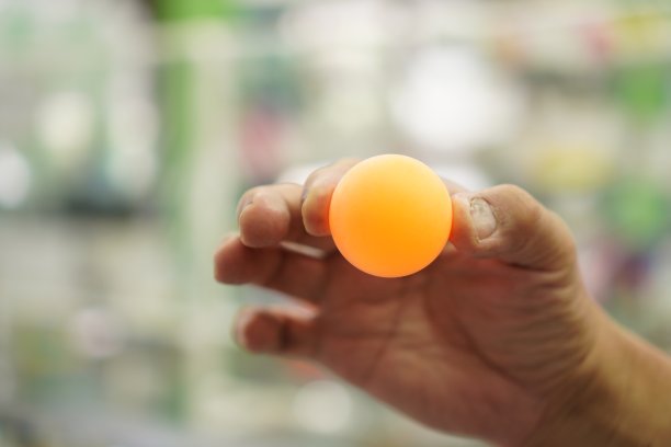 图片显示一个乒乓球在手，特写，室内运动图片下载