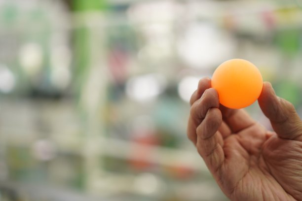 图片显示一个乒乓球在手，特写，室内运动图片下载