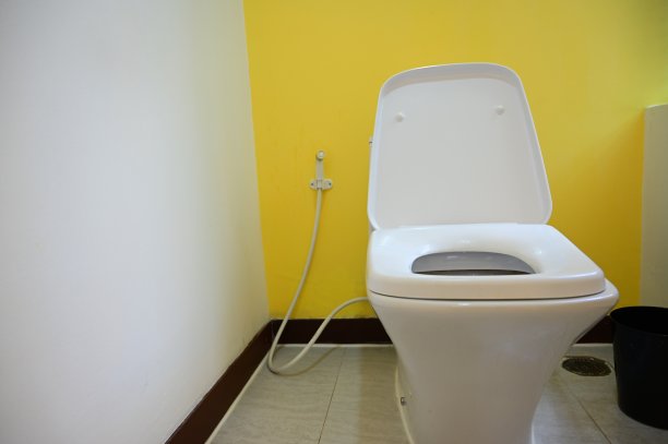 黄色墙壁的白色抽水马桶，室内设计图片下载