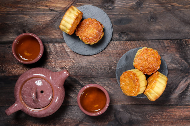 月饼餐桌设置-圆形中国传统糕点，木制背景上的茶杯，中秋节概念，接近。图片下载
