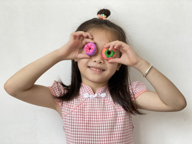 拿着迷你甜甜圈的亚洲小孩图片下载