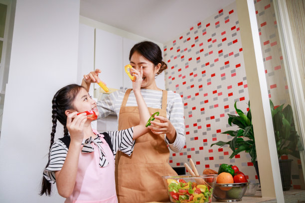 妈妈和孩子准备蔬菜沙拉的可爱时刻。健康食物和快乐图片下载