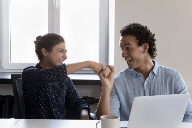 友好的多民族同事拳头碰撞庆祝良好的团队合作结果图片下载
