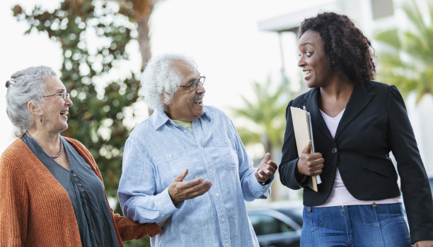 多种族的老年夫妇和房地产经纪人在户外散步图片下载