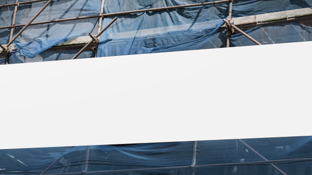 用脚手架固定在工地围栏上的白色空白帆布图片下载