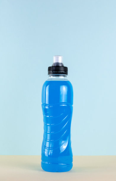 蓝色瓶等渗饮料，左旋肉碱，蓝色背景的运动能量饮料。运动瓶饮料-左旋肉碱和等渗宏。一瓶健身饮料。图片下载