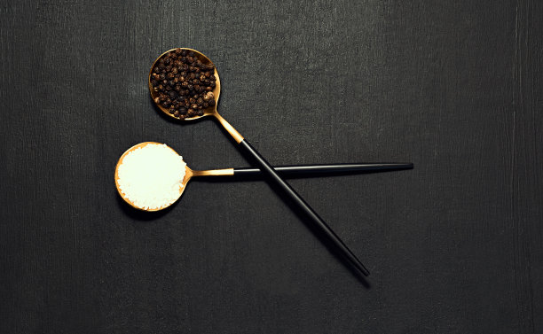 粗盐和胡椒勺子从上面的黑色木质表面烹饪，食物和调味拷贝空间的背景。餐厅的烹饪产品和静物从上面平放图片下载