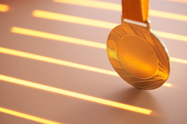 金牌对橙色背景的特写图片下载