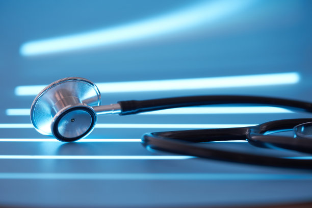 听诊器在柔和的蓝色背景与照明效果图片下载