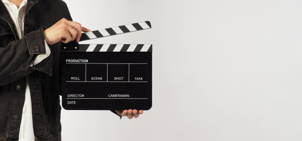 一名男子的身体部位拿着白色背景上的黑色隔板或电影石板。工作室拍摄图片下载