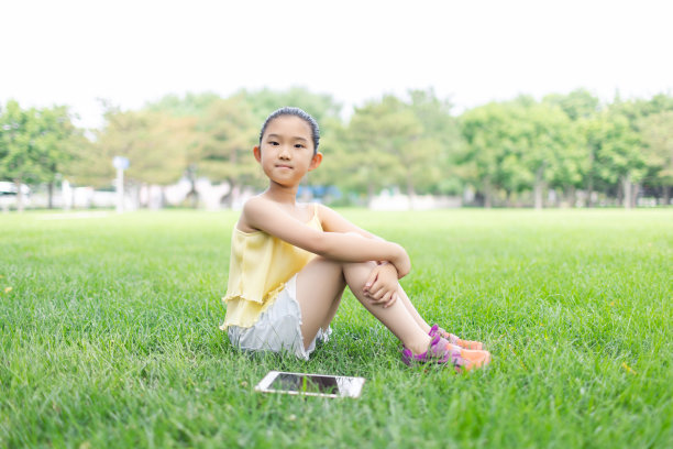 小学生坐在草地上图片下载