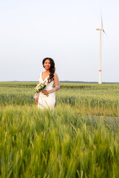 幸福的非裔美国新娘站在田野里的画像图片下载