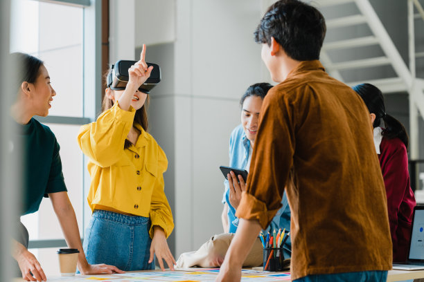 亚洲商人和商业女性会议头脑风暴的想法，使用vr眼镜(虚拟现实)测试移动应用程序开发软件一起工作在现代办公室。图片下载