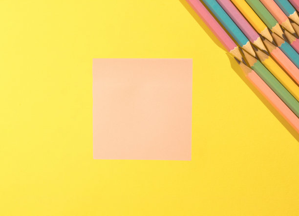 粉色空白记事本和黄色背景彩色木制铅笔。带有拷贝空间的俯视图。回到学校概念。图片下载