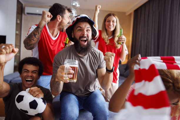 朋友们一边看电视上的足球比赛，一边开心地欢呼图片下载