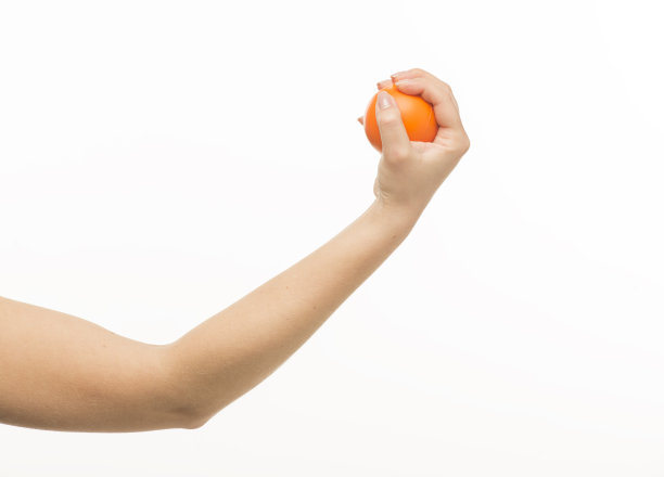 女性的手拿着一个橙色的海绵球，在白色的背景上孤立图片下载