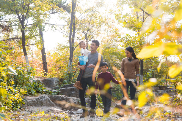 可爱的小女孩和她的妈妈在秋天的森林和山涧玩拍手游戏-股票照片图片下载