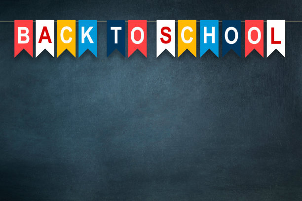 回到学校，字写在五颜六色的纸旗上，在校董会的背景上。新学年的概念。副本的空间。教育。图片下载