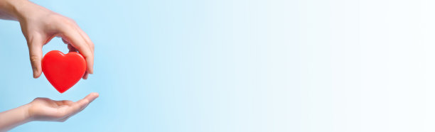 手的人把一颗心给另一个人在蓝色的背景。海报，横幅，文本拷贝空间图片下载