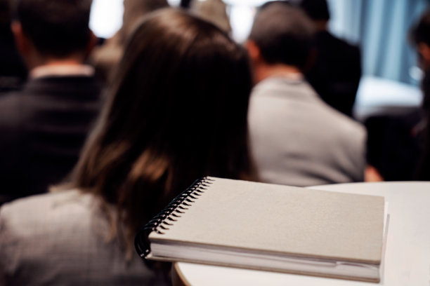桌子上的笔记本——人们坐在一起参加会议研讨会图片下载
